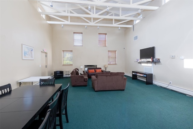 living room with dark colored carpet, beam ceiling, and high vaulted ceiling