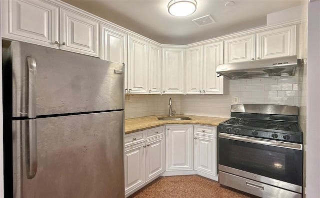 kitchen with white cabinets, stainless steel appliances, tasteful backsplash, and sink