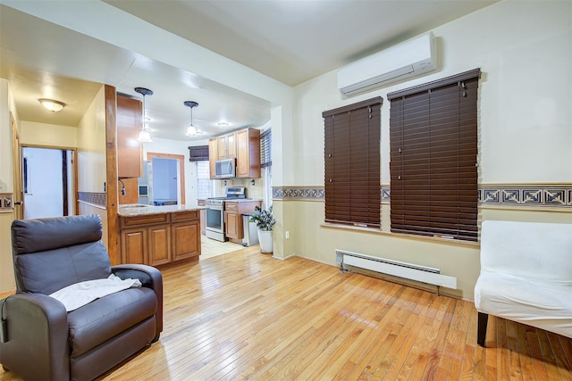 living room with a wall unit AC, baseboard heating, sink, and light wood-type flooring