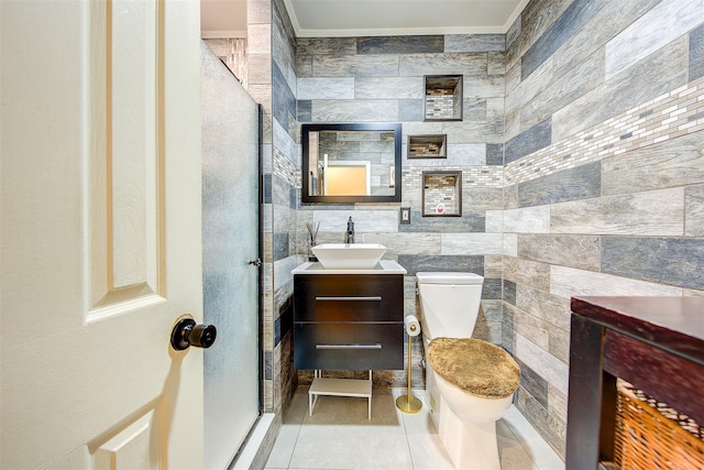 bathroom featuring vanity, tile patterned floors, toilet, ornamental molding, and tile walls