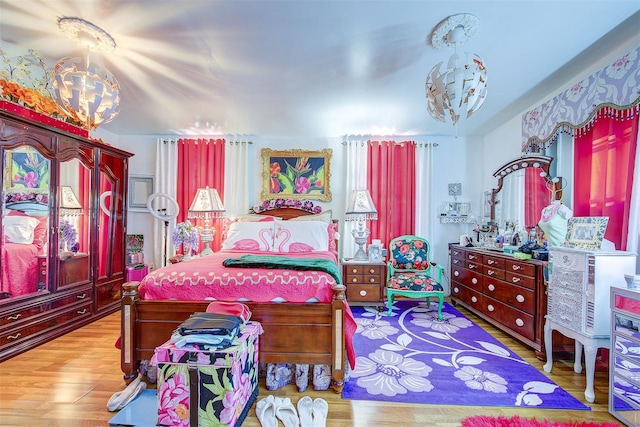 bedroom featuring hardwood / wood-style flooring and an inviting chandelier