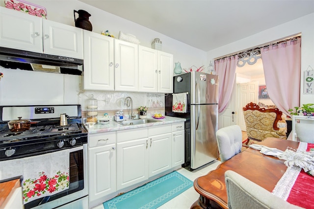 kitchen with appliances with stainless steel finishes, tasteful backsplash, white cabinetry, and sink