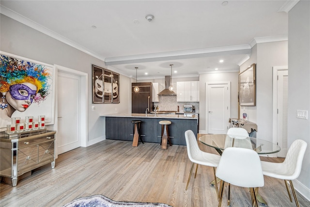 dining room with light wood-type flooring and crown molding