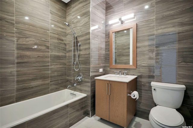 full bathroom with vanity, tiled shower / bath combo, tile walls, and toilet