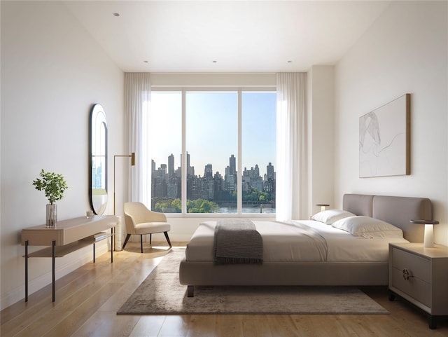 bedroom with multiple windows and light hardwood / wood-style floors