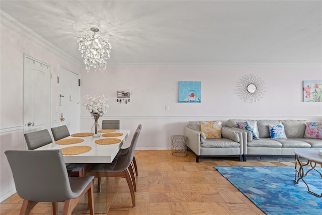 dining room featuring crown molding, light parquet flooring, and a chandelier