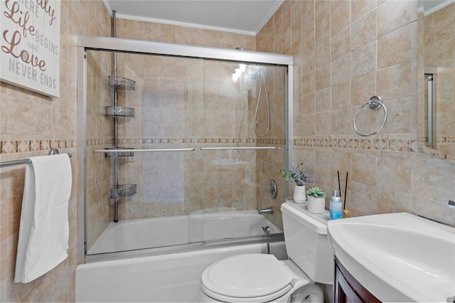 full bathroom with toilet, combined bath / shower with glass door, tile walls, and vanity