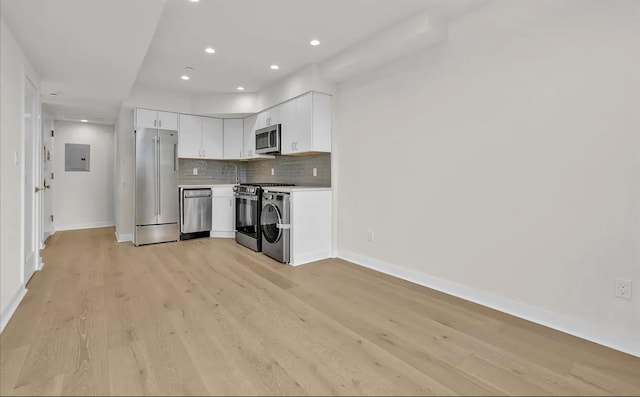 kitchen with stainless steel appliances, backsplash, electric panel, light hardwood / wood-style floors, and white cabinets