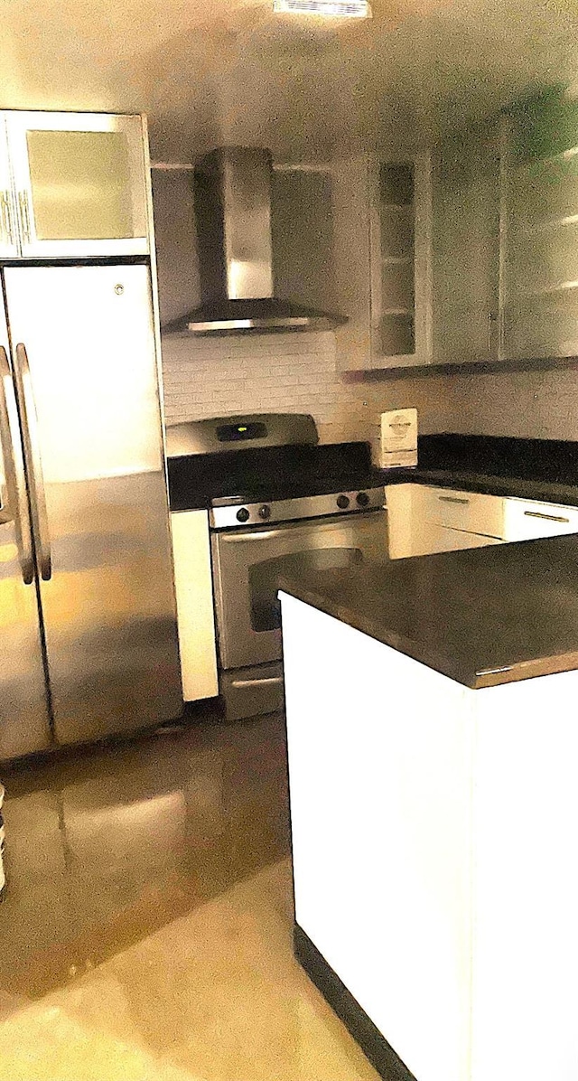 kitchen with appliances with stainless steel finishes, white cabinetry, and exhaust hood