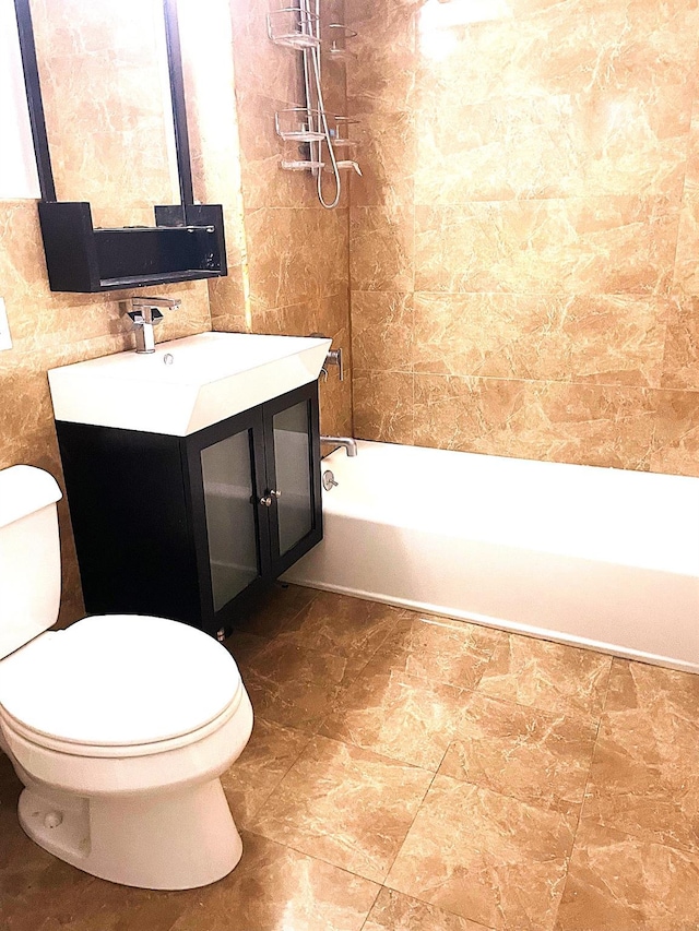 full bathroom with vanity, tub / shower combination, tile walls, and toilet