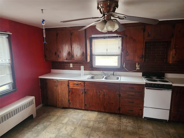 kitchen with sink, ceiling fan, tasteful backsplash, white range oven, and radiator heating unit