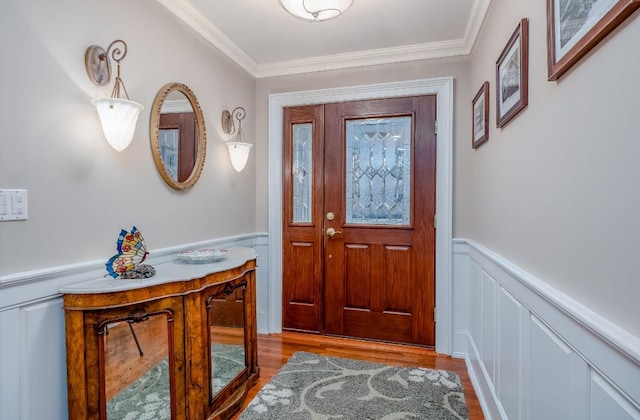 entryway with light hardwood / wood-style floors and ornamental molding