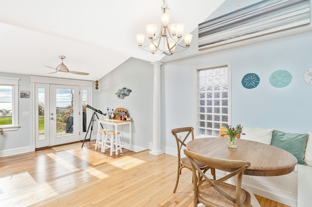 dining space featuring ceiling fan with notable chandelier, light hardwood / wood-style floors, and vaulted ceiling