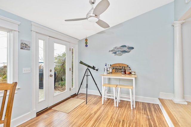 entryway featuring hardwood / wood-style flooring, ceiling fan, and decorative columns