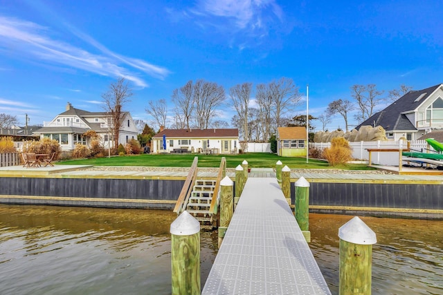 dock area with a water view and a lawn