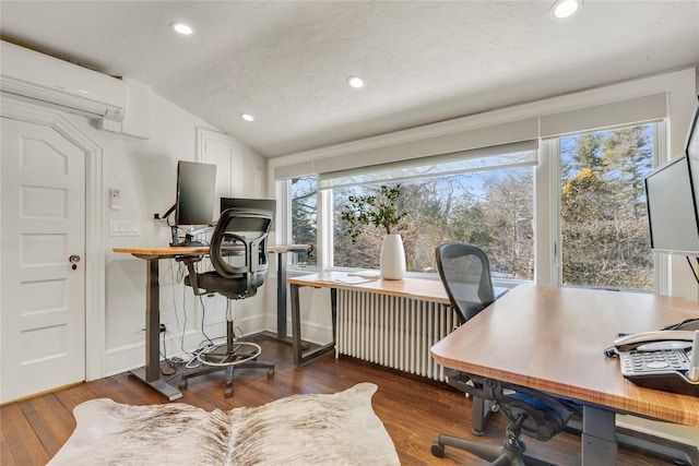 home office with lofted ceiling, radiator, a wall unit AC, dark hardwood / wood-style floors, and a textured ceiling