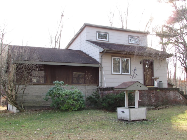 rear view of property featuring a lawn