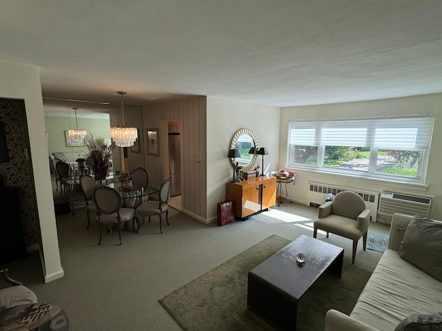 carpeted living room featuring radiator heating unit, a wall unit AC, and a notable chandelier