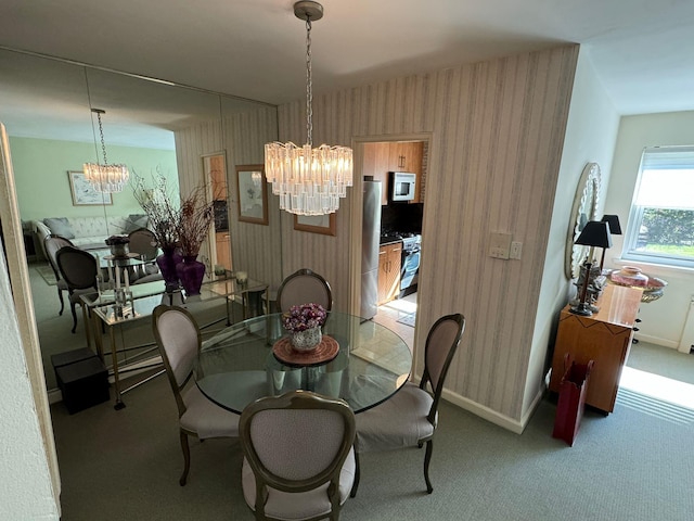 dining space featuring light colored carpet and an inviting chandelier