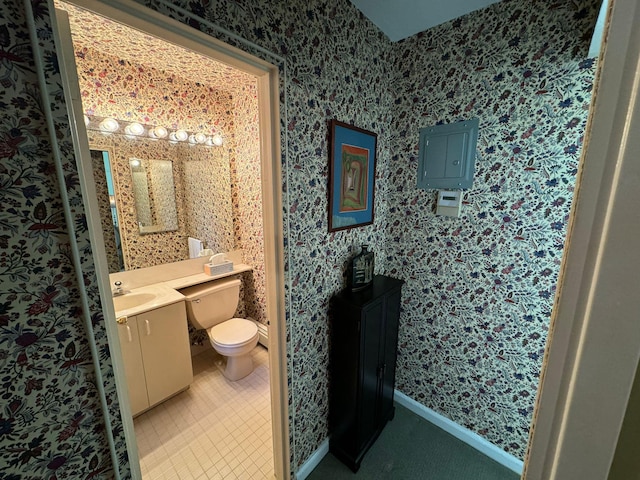 bathroom featuring tile patterned flooring, vanity, electric panel, and toilet