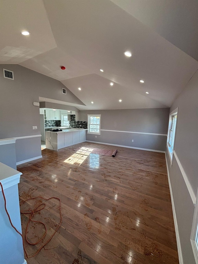 unfurnished living room featuring lofted ceiling and hardwood / wood-style flooring