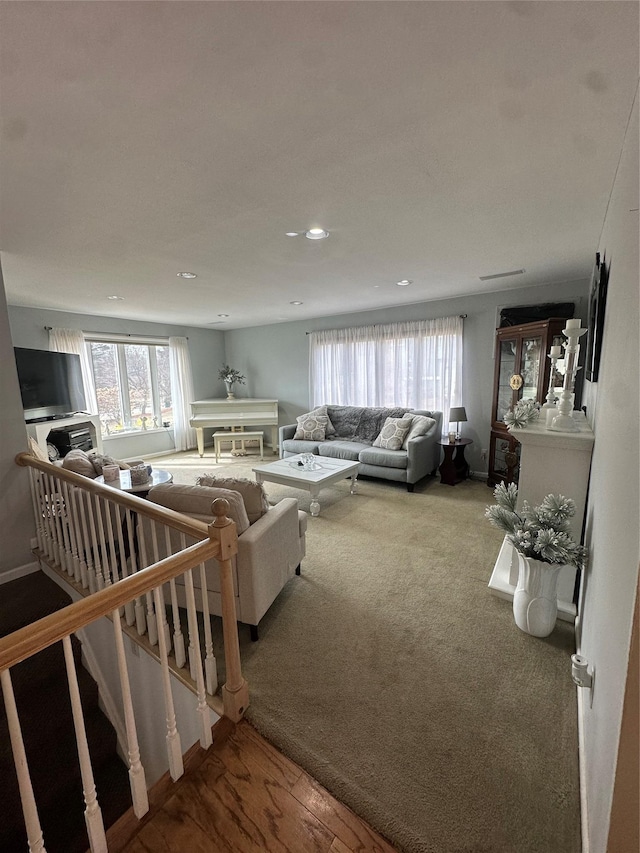 carpeted living room with stairs, recessed lighting, a healthy amount of sunlight, and baseboards