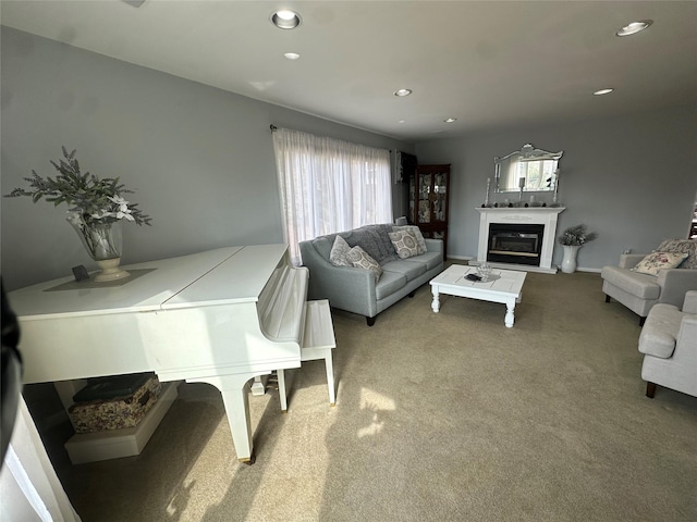 carpeted living area with a glass covered fireplace, recessed lighting, and baseboards