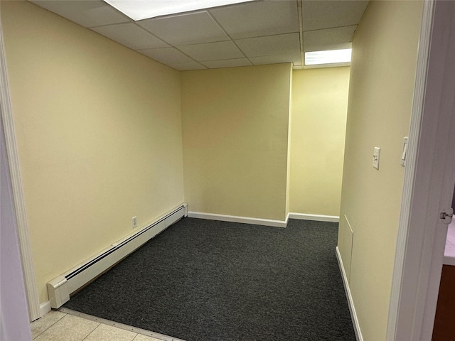 carpeted empty room featuring a baseboard radiator, a paneled ceiling, and baseboards