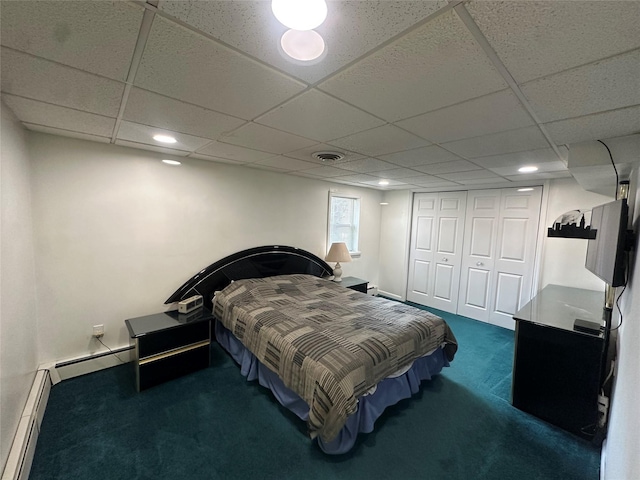 bedroom featuring a baseboard heating unit, carpet, visible vents, and a closet