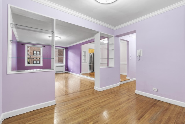 interior space with hardwood / wood-style flooring, radiator heating unit, and crown molding