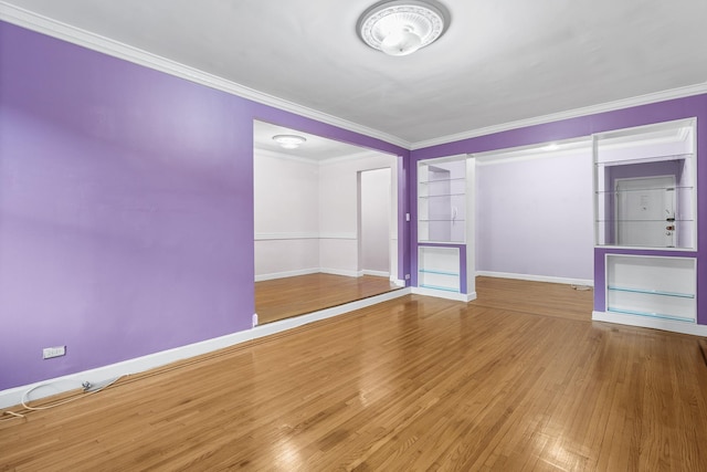 spare room with hardwood / wood-style flooring and crown molding