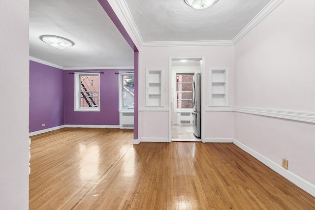 interior space with built in shelves, radiator heating unit, ornamental molding, and hardwood / wood-style flooring