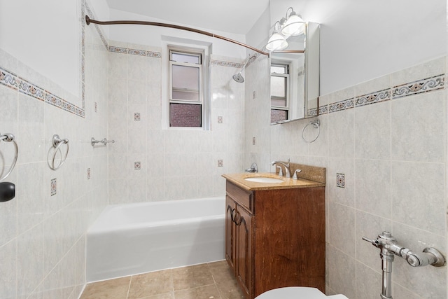 bathroom with vanity, tile patterned floors, tile walls, and tiled shower / bath combo