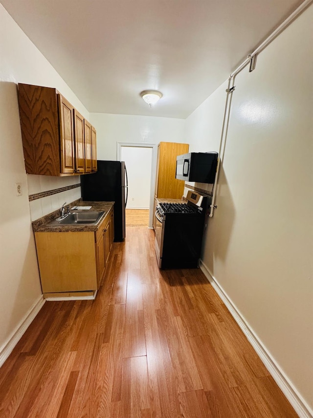 kitchen with hardwood / wood-style flooring, sink, and appliances with stainless steel finishes