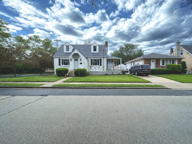 33 Farnum St, Lynbrook, NY 11563 - cape cod-style house featuring a front yard, concrete driveway, and a chimney