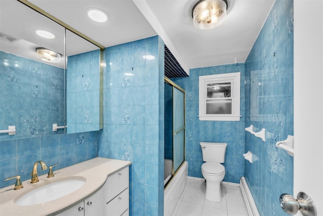 full bathroom with combined bath / shower with glass door, a baseboard heating unit, toilet, vanity, and tile walls
