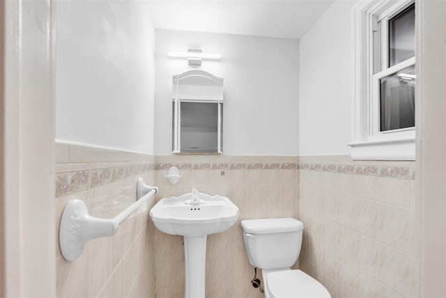 bathroom featuring toilet and tile walls