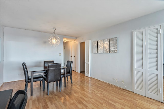 dining area with a notable chandelier and light hardwood / wood-style flooring