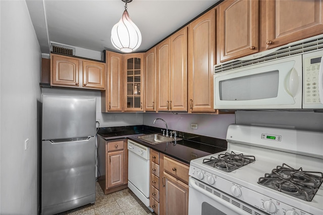 kitchen with white appliances, decorative light fixtures, and sink