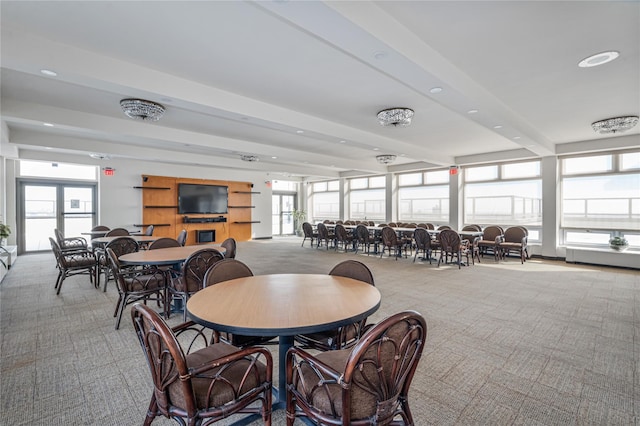 carpeted dining area featuring plenty of natural light and beamed ceiling