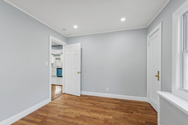 unfurnished room featuring crown molding, radiator heating unit, and hardwood / wood-style floors