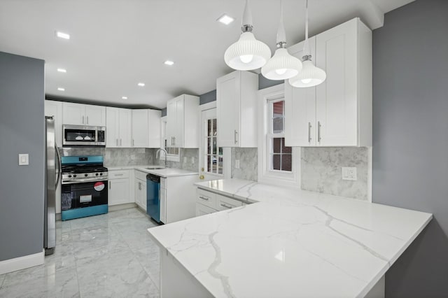 kitchen featuring white cabinets, appliances with stainless steel finishes, decorative light fixtures, light stone counters, and kitchen peninsula