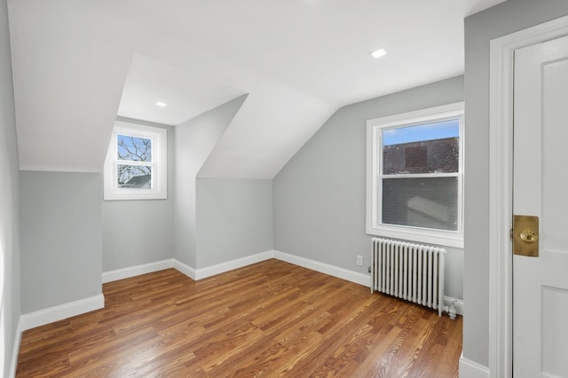 bonus room featuring hardwood / wood-style flooring, radiator, and lofted ceiling