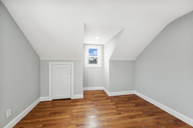 additional living space with dark hardwood / wood-style floors and vaulted ceiling