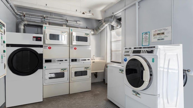 washroom with washing machine and dryer, stacked washing maching and dryer, and sink