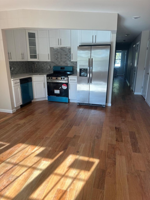 kitchen with white cabinets, appliances with stainless steel finishes, tasteful backsplash, and dark wood-type flooring