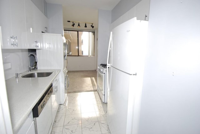 kitchen featuring sink, washer / clothes dryer, light colored carpet, white appliances, and white cabinets