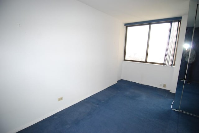 unfurnished room with dark colored carpet