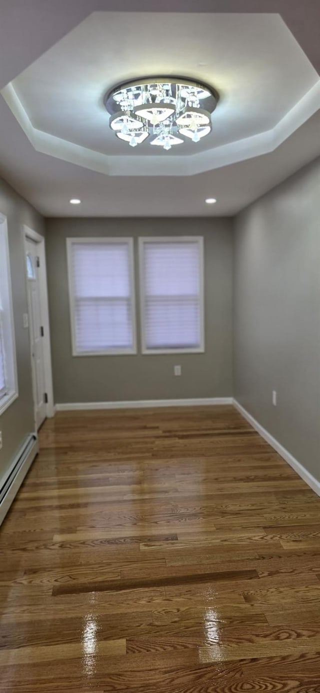 spare room featuring dark hardwood / wood-style floors and a raised ceiling