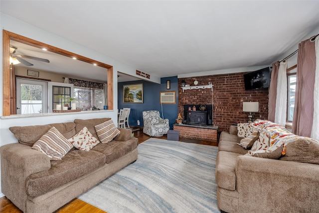 living room with ceiling fan, wood-type flooring, and a wall mounted air conditioner